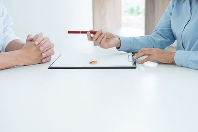 Close-up of couple signing divorce document 