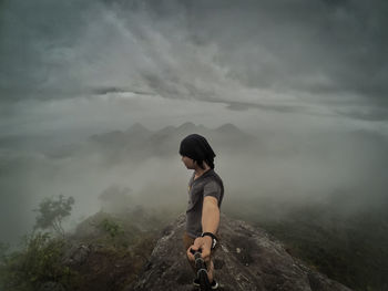 Full length of man standing on mountain against sky