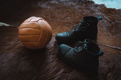 High angle view of soccer ball and boots on brown fur