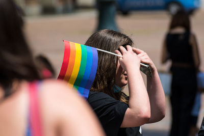 Rear view of woman holding multi colored umbrella