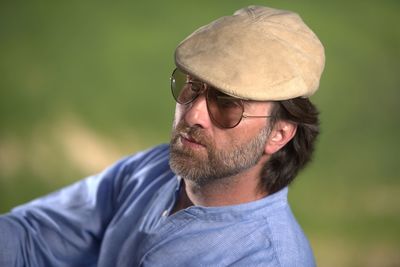 Mature man wearing cap and sunglasses while looking away outdoors