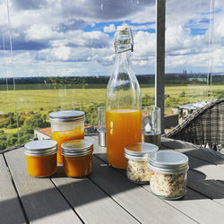 Close-up of a glasses of sea buckthorn stuff,  salt ,lemonade and marmalade on table against sky