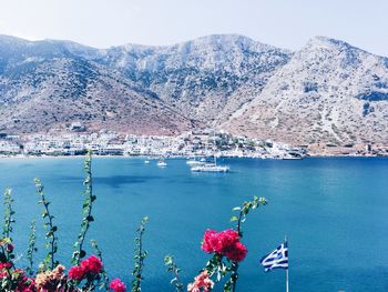 Scenic view of sea by mountains against sky