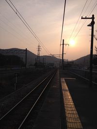 Railroad tracks against sky during sunset