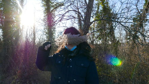 Man standing by tree in forest
