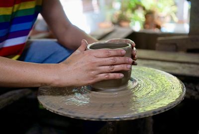 Focus of hands sculpting clay on potter wheel