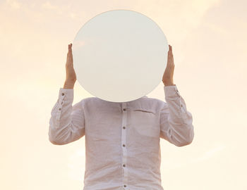 Rear view of woman wearing hat against yellow background