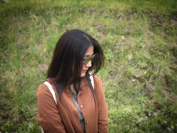 Woman wearing sunglasses while standing on field