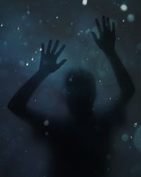 Close-up of silhouette hand touching glass