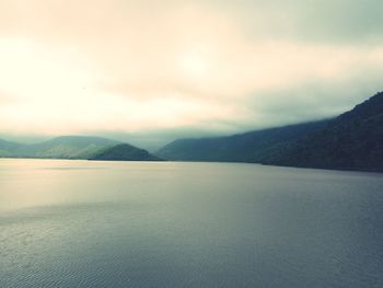 Scenic view of sea and mountains against sky