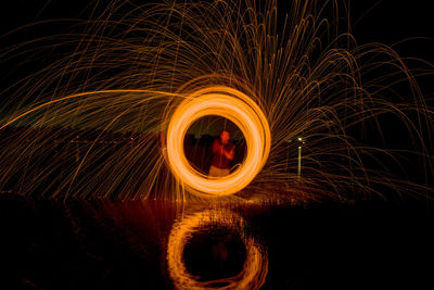 Man spinning wire wool at night