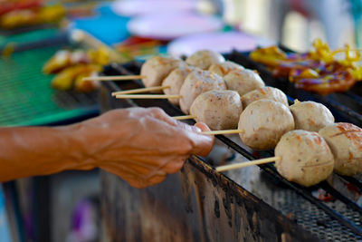 Person preparing food on barbecue grill