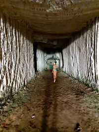 Rear view of woman standing in tunnel