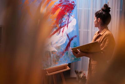 Side view of woman standing against wall