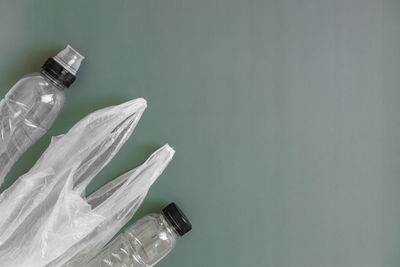 Plastic bag and bottles on a green background.