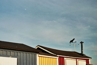 Low angle view of weather vane against sky