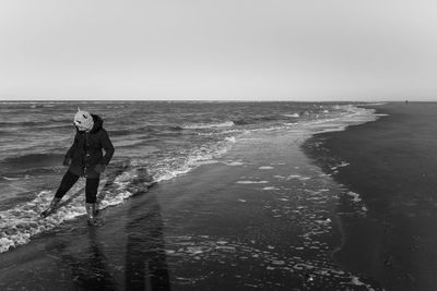 Woman on beach against clear sky