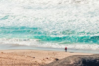 Man standing on beach by sea