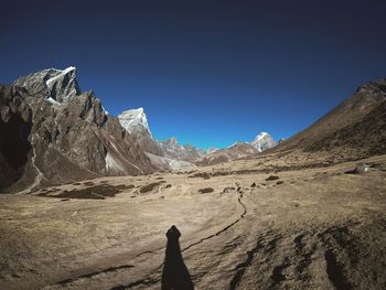 Scenic view of snowcapped mountains against clear blue sky