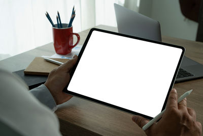 Cropped hands using laptop at table