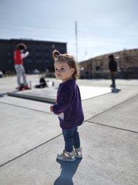 Side view of girl standing against the sky