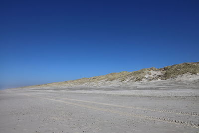Scenic view of desert against clear blue sky