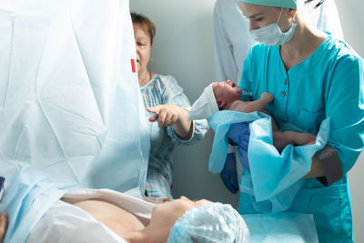 Midsection of doctor examining patient in hospital