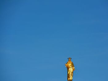 Low angle view of statue against blue sky