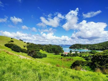 Scenic view of green landscape against cloudy sky