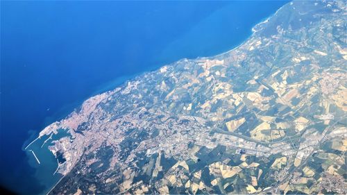 Aerial view of sea and cityscape against sky