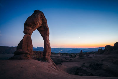 Rock formation on land against sky during sunset