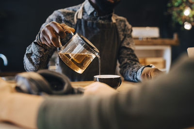 Midsection of man holding beer glass