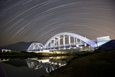 Bridge over river against sky at night