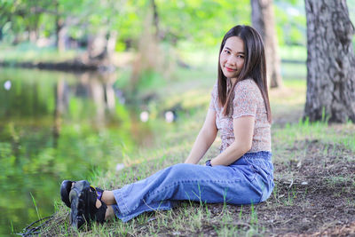 Portrait of young woman sitting on land