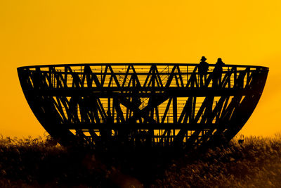 Silhouette man standing against orange sky