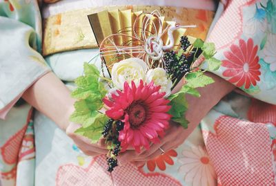 Midsection of woman holding flowers