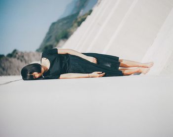 Full length portrait of woman lying on land