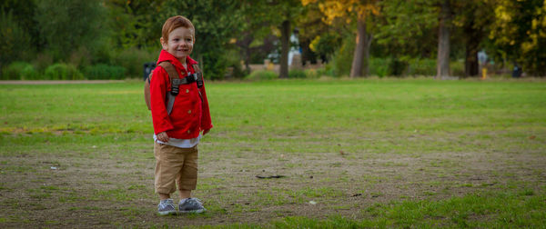 Full length of boy standing on grassy field in park
