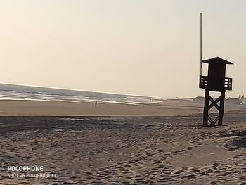 Lifeguard hut on beach against clear sky