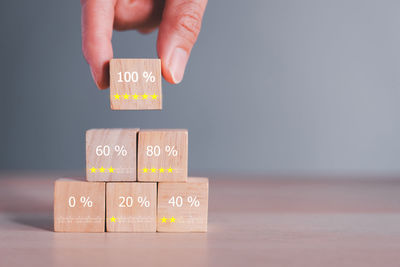 Cropped hand with toy blocks with text on wooden block on table