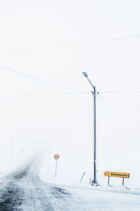 Snow covered landscape with a countryside road disappearing into to the fog