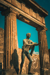 Low angle view of statue against old building