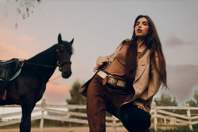 Portrait of young woman standing against sky