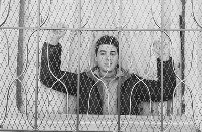 Portrait of man seen through fence