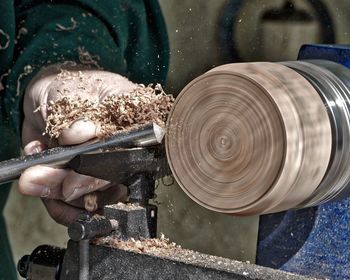 Midsection of man working on wood at workshop