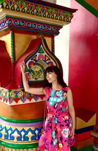 Full length of woman standing against multi colored wall