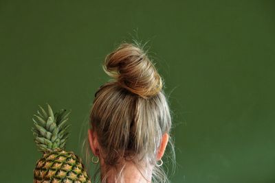 Rear view of woman with pineapple 