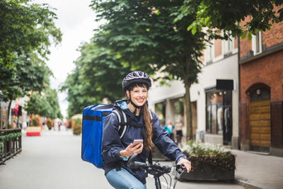 Portrait of smiling man on bicycle in city