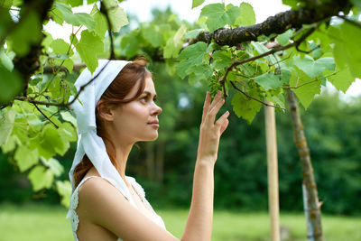 Low angle view of young woman against plants