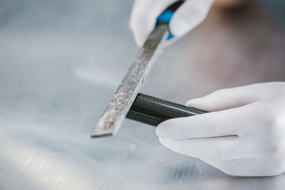 Cropped hands of person shaping pipe at workshop